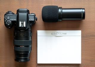 Camera, microphone, and notepad on a desk